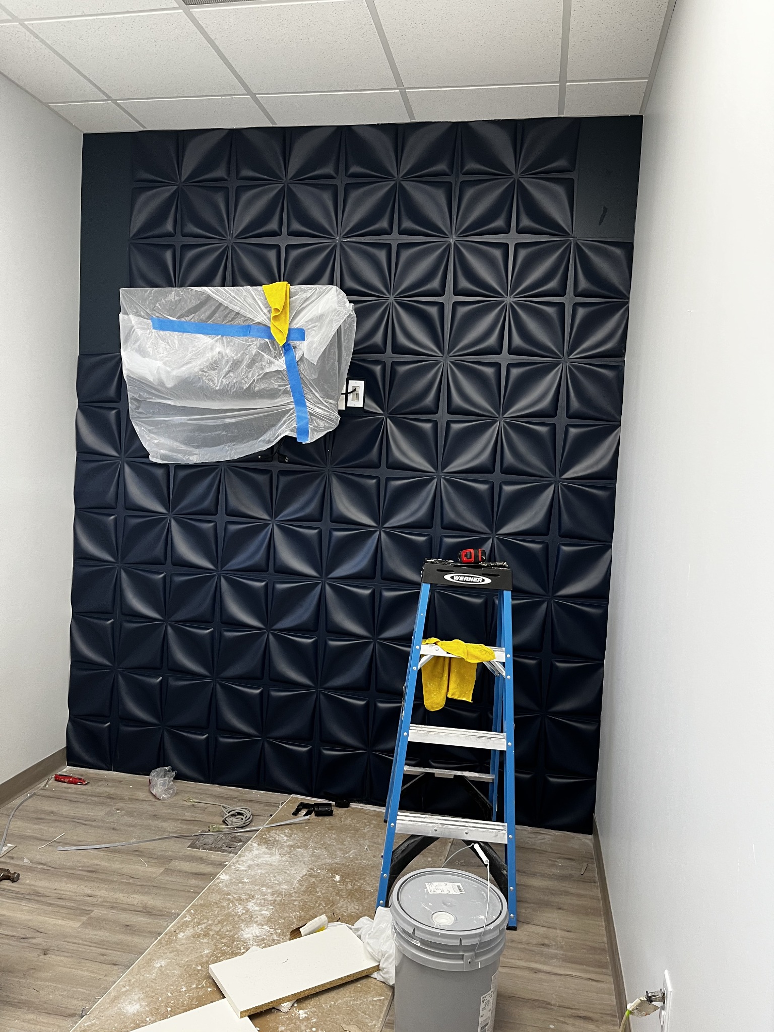 Dimensional dark accent wall installation in progress